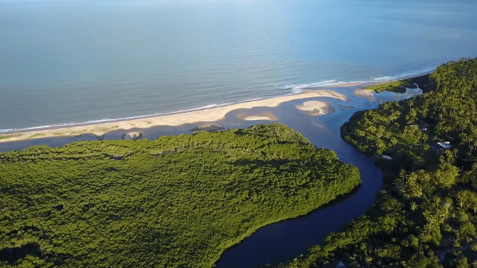 Vista aérea do Rio Corumbau encontrando o mar, com bancos de areia e manguezal