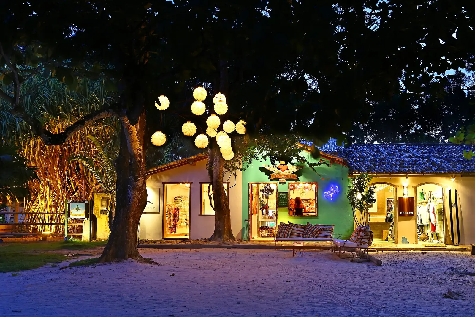 Casario do Quadrado de Trancoso iluminado sob as árvores ao anoitecer