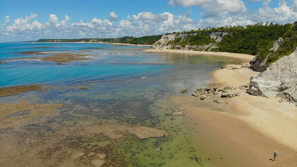 Piscinas naturais e falésias da Praia do Espelho na maré baixa