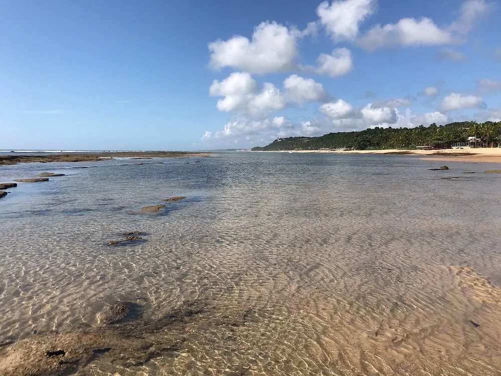 Águas rasas e recifes na Praia do Mucugê durante a maré baixa