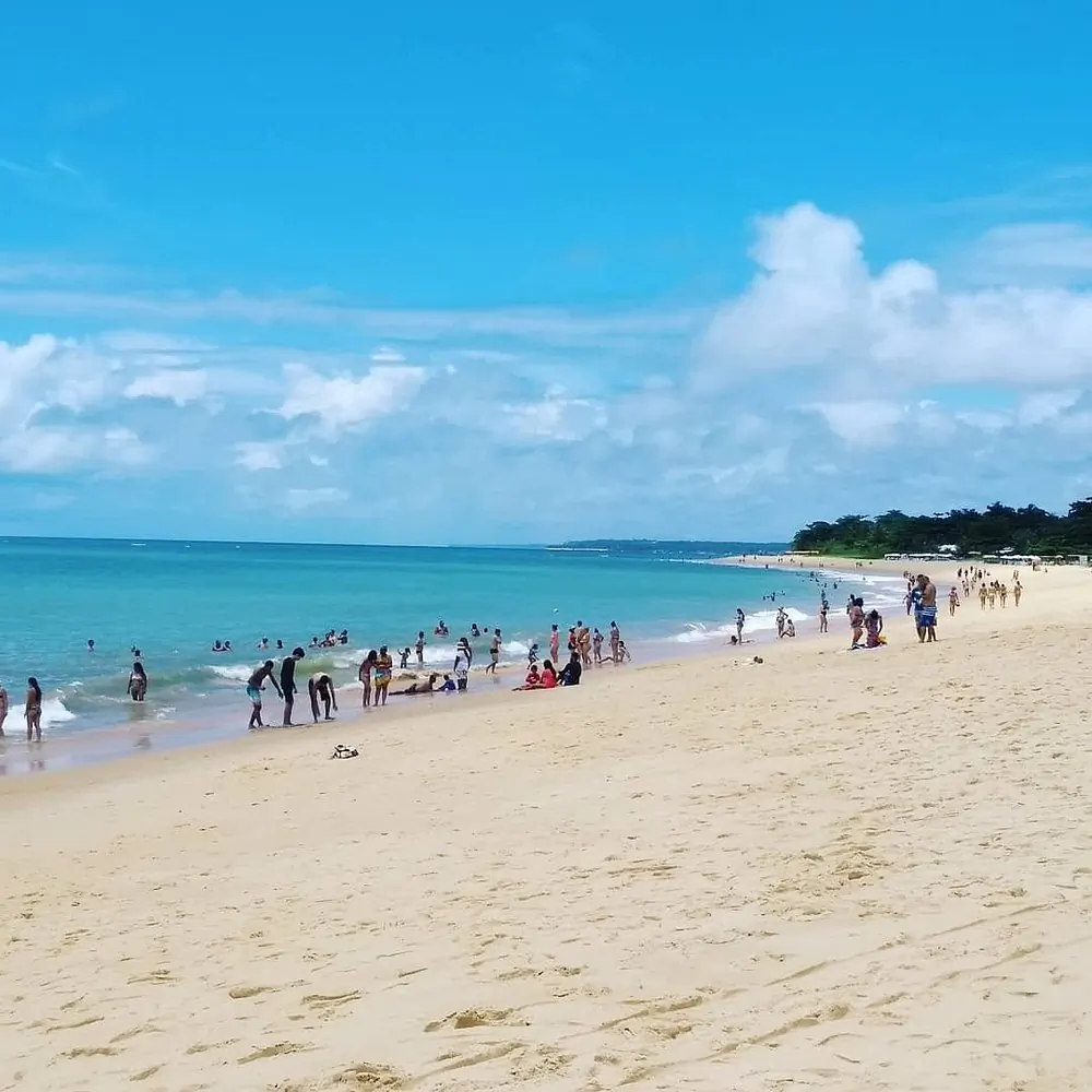 Banhistas no mar azul da Praia de Taperapuã